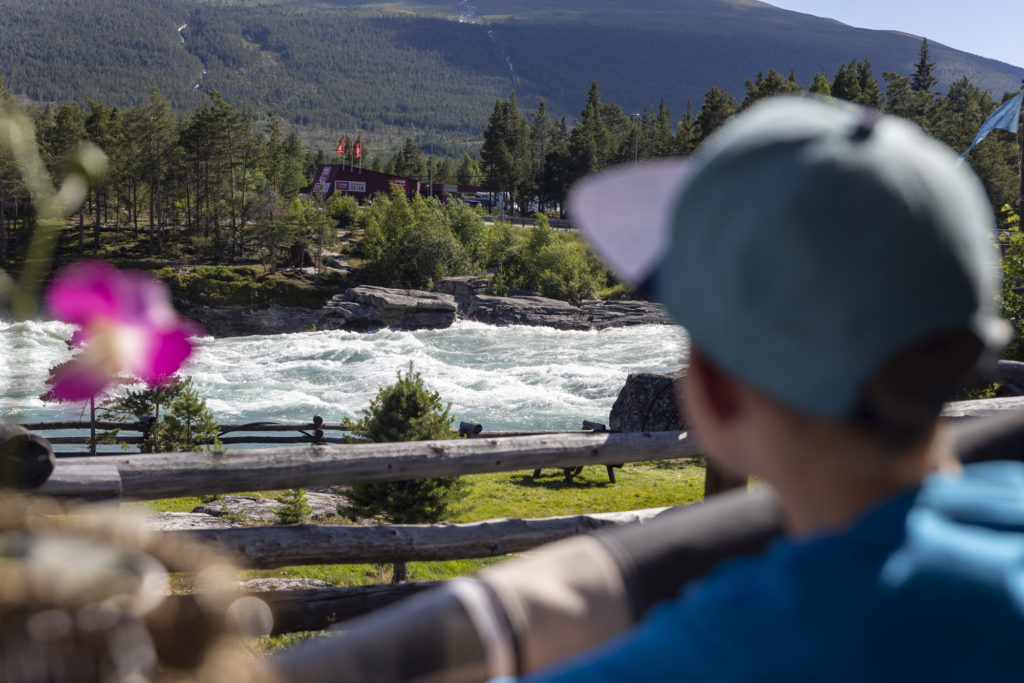 Campinggjest som koser seg med utsikt over Dønfossen som bukter seg forbi campingplassen.